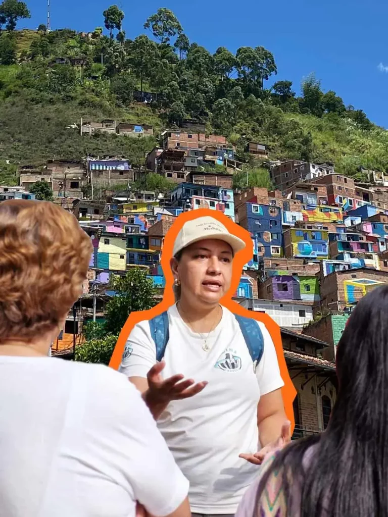 Guía local de turismo comunitario en Constelaciones, comuna 3 de Medellín, comparte historia con viajeros frente a casas típicas del barrio.