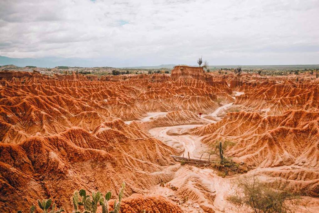 Paisaje árido del Desierto de la Tatacoa, Huila, con formaciones rocosas y senderos entre cañones rojizos.