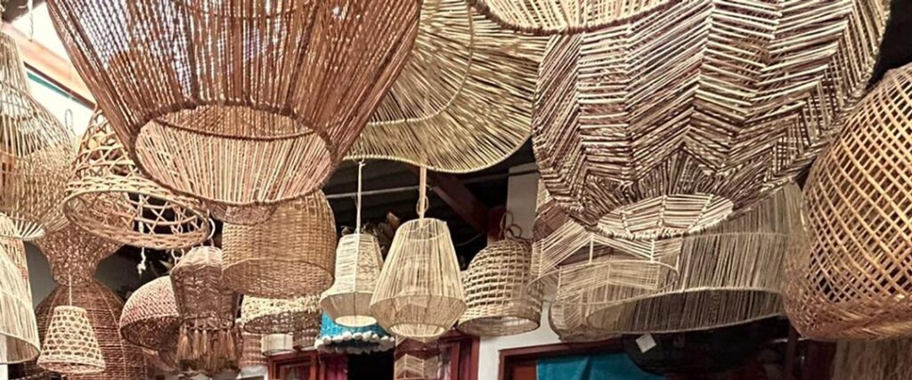 Lámparas de fibras naturales colgando del techo en taller artesanal en Filandia, Quindío